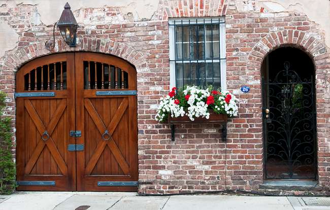 Charleston, South Carolina, USA.  Spring flowers bloom in a window box on the face of a historic brick building in downtown Charleston