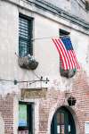 Charleston, South Carolina, USA.  An American flag waves in the breeze outside a historic Charleston building.